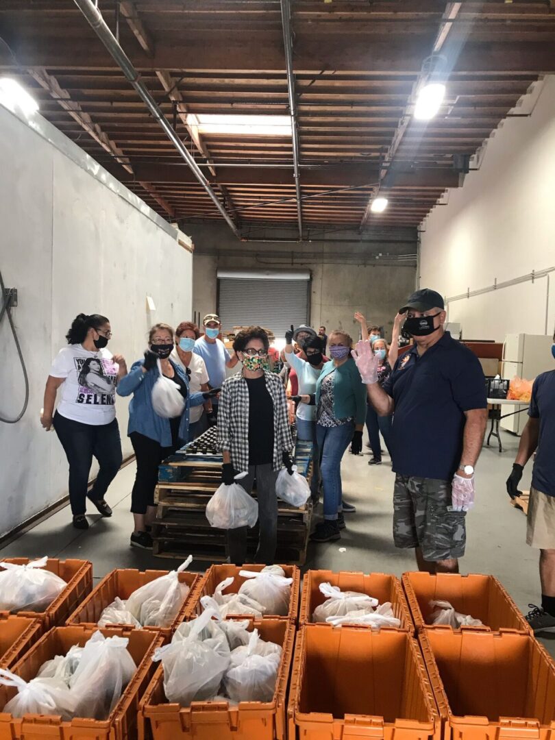 A group of people standing around some food.